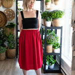 Haut noir et jupe rouge portés par la silhouette Claudie (M).