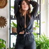 Chemise masculine ample noire nouée au devant pour femme.