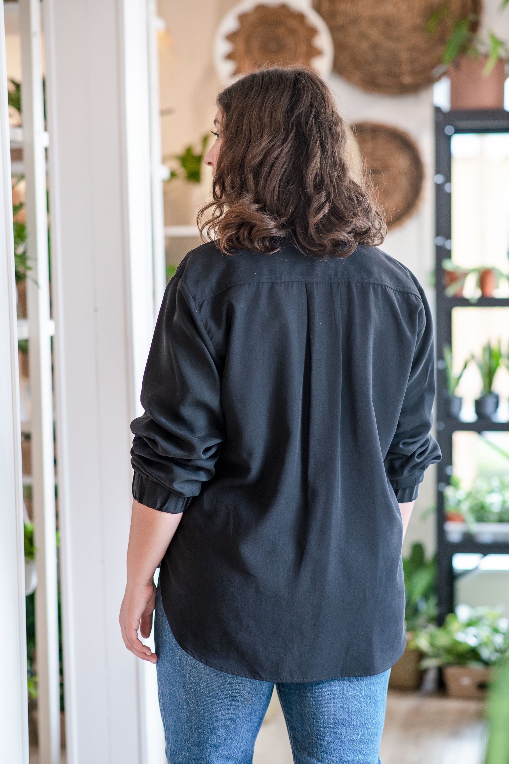 Chemise masculine ample noire de dos portée par la silhouette Sophia (L).